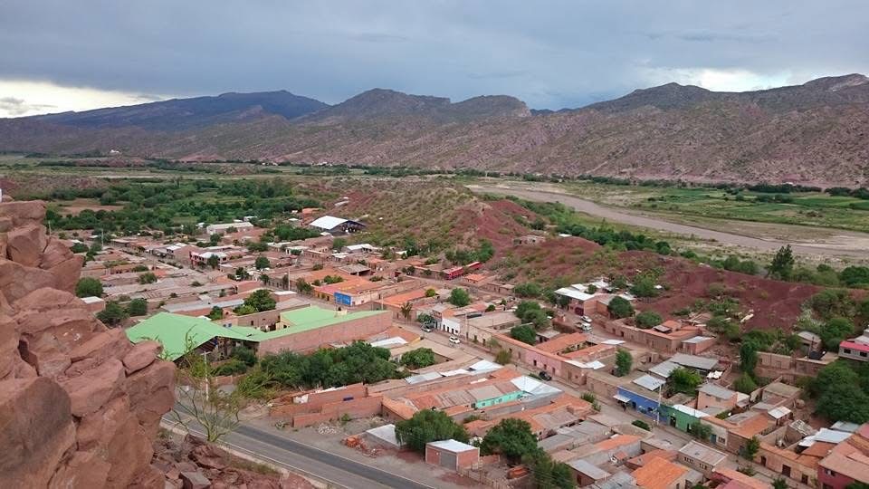 Vista panorámica de un pueblo y un valle bajo un cielo nublado.